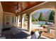 Covered patio featuring stone flooring, ceiling fan, offers stunning views of the inviting pool and backyard at 300 Annelise Park Dr, Fayetteville, GA 30214