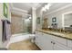 Bright bathroom featuring granite countertop, framed mirror, shower-tub combo with decorative tile and a toilet at 300 Annelise Park Dr, Fayetteville, GA 30214