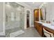 Bathroom with marble shower, wood cabinets, double vanity, and access to a walk-in closet at 300 Annelise Park Dr, Fayetteville, GA 30214