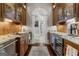This beautiful butler's pantry features wood cabinets, granite counters, under cabinet lighting, and a wine fridge at 300 Annelise Park Dr, Fayetteville, GA 30214