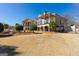 Stunning backyard of home featuring a large manicured lawn, mature trees, and an attached outdoor living space at 300 Annelise Park Dr, Fayetteville, GA 30214
