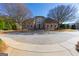 Imposing exterior showcasing the home's symmetrical design, circular driveway, and mature trees at 300 Annelise Park Dr, Fayetteville, GA 30214