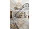 Spacious foyer features a curved staircase with wrought iron railing, stone floors and a chandelier at 300 Annelise Park Dr, Fayetteville, GA 30214