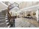 Open foyer with curved staircase, dining room, and living room, with stone tile flooring at 300 Annelise Park Dr, Fayetteville, GA 30214