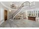 Grand foyer with a curved staircase, a fireplace, and natural light from the large windows at 300 Annelise Park Dr, Fayetteville, GA 30214