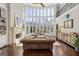Living room with tall windows, fireplace, dark hardwood floors, and a brown leather couch at 300 Annelise Park Dr, Fayetteville, GA 30214