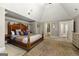 A large main bedroom with a decorative wooden bed frame and neutral paint, and a view into the ensuite bathroom at 300 Annelise Park Dr, Fayetteville, GA 30214