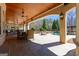 Covered outdoor patio with stone flooring, wood ceilings, dining, seating, and a pool view at 300 Annelise Park Dr, Fayetteville, GA 30214