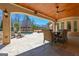 Covered patio with ceiling fan offers an inviting view of the pool, stone patio, and landscape at 300 Annelise Park Dr, Fayetteville, GA 30214