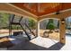Covered patio featuring stone flooring, elegant lighting, and stairway to upper level, overlooking lush landscaping at 300 Annelise Park Dr, Fayetteville, GA 30214