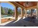 Charming covered patio with stone flooring, overlooking the inviting pool and landscaped backyard at 300 Annelise Park Dr, Fayetteville, GA 30214