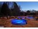 Inviting pool area featuring a jacuzzi, waterfalls, ambient lighting, and a shaded pergola with outdoor furniture at 300 Annelise Park Dr, Fayetteville, GA 30214