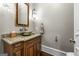 Charming powder room with decorative sink basin, wood vanity, granite counter, and decorative light fixture at 300 Annelise Park Dr, Fayetteville, GA 30214