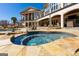 The spa features blue mosaic tile and is surrounded by rock and has nearby lounge chairs at 300 Annelise Park Dr, Fayetteville, GA 30214