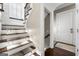 Elegant staircase with custom carpet runner, white wainscoting and trim, and craftsman dark wood banister at 300 Annelise Park Dr, Fayetteville, GA 30214