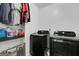 Functional laundry room with sleek black washer and dryer, complemented by shelf with laundry supplies at 70 High Point Way, Hiram, GA 30141
