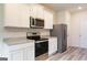 Well-lit kitchen features white cabinets, stainless steel appliances, and granite countertops at 293 Limestone Circle, Conyers, GA 30013