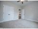 A simple bedroom with neutral walls, plush carpet, a ceiling fan, and an interior closet at 3264 Greenhill Ct, Villa Rica, GA 30180