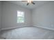 Bright, carpeted bedroom featuring a window and ceiling fan at 3264 Greenhill Ct, Villa Rica, GA 30180