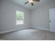 Bright, carpeted bedroom featuring a window and ceiling fan at 3264 Greenhill Ct, Villa Rica, GA 30180