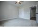 A simple bedroom with neutral walls, plush carpet, a ceiling fan, and an interior closet at 3264 Greenhill Ct, Villa Rica, GA 30180