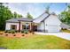 Charming home featuring white siding, a black roof, wood accents, professionally landscaped lawn and an attached two-car garage at 3264 Greenhill Ct, Villa Rica, GA 30180