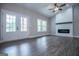 Bright living room featuring a modern fireplace, ceiling fan, and double doors to the outdoors at 3264 Greenhill Ct, Villa Rica, GA 30180