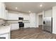 Bright kitchen with stainless steel appliances, white cabinets, and hard wood floors at 928 Hesston Dr, Locust Grove, GA 30248