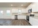 Modern kitchen with white cabinets, stainless steel appliances, and hardwood floors at 928 Hesston Dr, Locust Grove, GA 30248