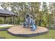 Community playground with a blue slide, play structure, shaded pavilion, bench seating, and wood chip ground at 928 Hesston Dr, Locust Grove, GA 30248