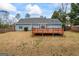 Home featuring a wooden deck, a well-maintained lawn, and mature trees providing a private backyard at 10 Allen Oaks Way, Covington, GA 30016