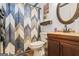 Small bathroom with toilet and vanity featuring dark wood cabinets and decorative mirror at 10 Allen Oaks Way, Covington, GA 30016