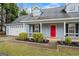 Close-up of a beautiful home's facade with a bright red door, manicured shrubs, and a convenient attached garage at 10 Allen Oaks Way, Covington, GA 30016