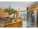 Functional kitchen with granite counters, stainless steel refrigerator, and breakfast bar area for casual dining at 10 Allen Oaks Way, Covington, GA 30016