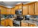 Updated kitchen featuring granite counters, stainless steel appliances, and ample wooden cabinetry at 10 Allen Oaks Way, Covington, GA 30016