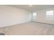 Bedroom featuring neutral carpet, two windows for natural light, and base trim at 1041 Claas Way, Locust Grove, GA 30248