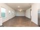 Open-concept living room features a ceiling fan, large windows, and wood-look flooring at 1041 Claas Way, Locust Grove, GA 30248