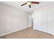 A bright bedroom featuring wood-look flooring, neutral walls, and a double door closet for storage at 135 Weeping Willow Way, Tyrone, GA 30290