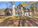 Rear view of the home's exterior with ample windows and a blue door, surrounded by lush greenery at 135 Weeping Willow Way, Tyrone, GA 30290