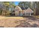 Traditional two-story home with well-maintained lawn, mature trees, and a bright blue front door provides a welcoming curb appeal at 135 Weeping Willow Way, Tyrone, GA 30290