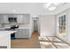 A bright kitchen with gray cabinets, modern lighting, and a large window with a view of the outdoors at 135 Weeping Willow Way, Tyrone, GA 30290