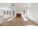 Spacious living room featuring wood-look floors, a stone fireplace, and a wall of windows for natural light at 135 Weeping Willow Way, Tyrone, GA 30290