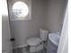 A half bath includes a toilet, sink, and round window at 2401 Northlake Ct, Atlanta, GA 30345
