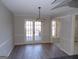 Dining area with modern light fixture, neutral color walls, laminate flooring, and access to the outdoor deck at 2401 Northlake Ct, Atlanta, GA 30345