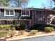 Brick townhome featuring well-maintained landscaping, a grey shingled section, and multiple windows for ample natural light at 2401 Northlake Ct, Atlanta, GA 30345