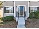 Close-up of the front entrance with a black door, white trim, black shutters, and well-maintained landscaping at 2561 Rainover Ct, Decatur, GA 30034