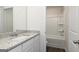 Bright bathroom featuring a granite countertop, white vanity and combination shower and tub at 275 Oliver Dr, Locust Grove, GA 30248