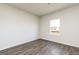 Simple bedroom featuring hardwood floors, neutral walls, and natural light from a window at 275 Oliver Dr, Locust Grove, GA 30248