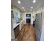 Galley kitchen with white cabinets, stainless appliances, and hardwood floors that goes into dining room at 3370 Creek Hollow Dr, Marietta, GA 30062