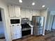 Kitchen with stainless appliances, black gas stove and hardwood floors. Microwave and cabinets surrounding at 3370 Creek Hollow Dr, Marietta, GA 30062